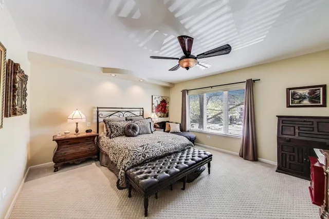 a bedroom with a large bed a chandelier and closet