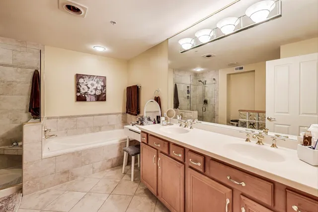 a bathroom with a tub a sink and mirror