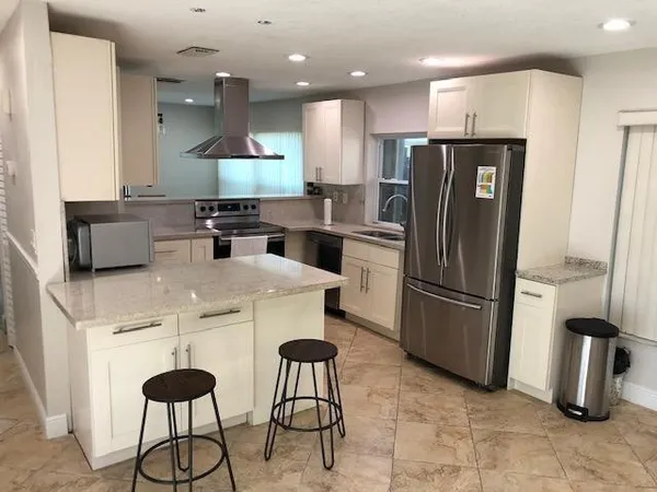 a kitchen with stainless steel appliances a refrigerator a stove a sink and a refrigerator