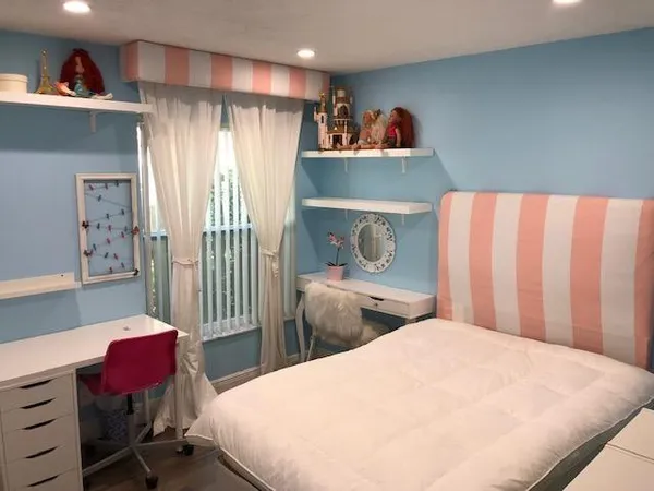 a bedroom with a bed and a refrigerator