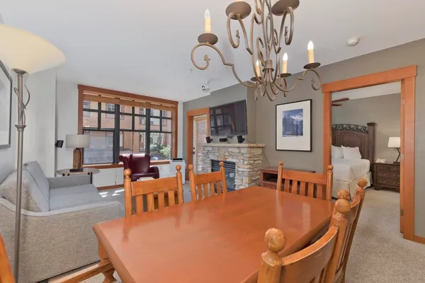 a living room with dining table a large window with wooden floors