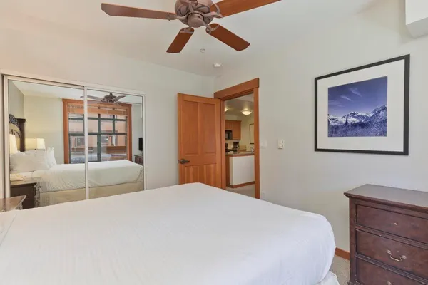 a bedroom with a large bed and a chandelier