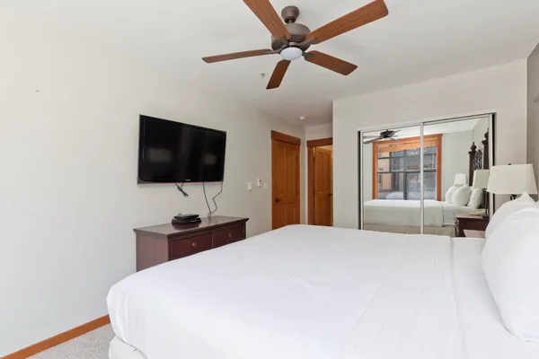 a bedroom with a bed and a flat screen tv