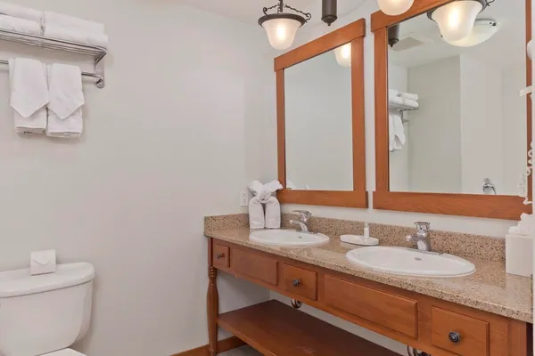 a bathroom with a granite countertop sink mirror and a toilet