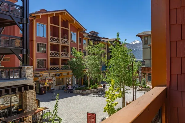a view of tall building with large windows and plants