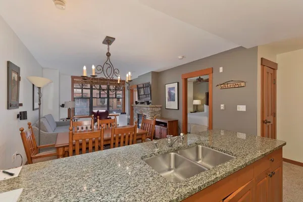 a very nice looking kitchen with granite countertop a sink and a large window