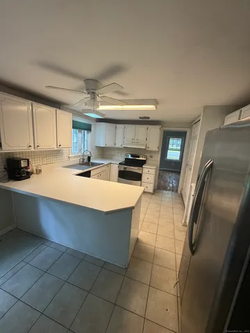 a kitchen with stainless steel appliances a refrigerator a sink a stove top oven a counter space and cabinets