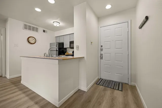 a kitchen with kitchen island a sink and a refrigerator