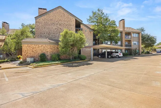 a car parked in front of a brick house with a yard