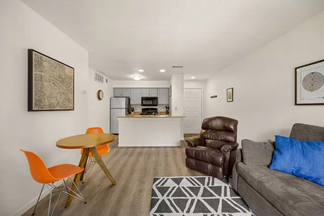 a living room with furniture and kitchen view