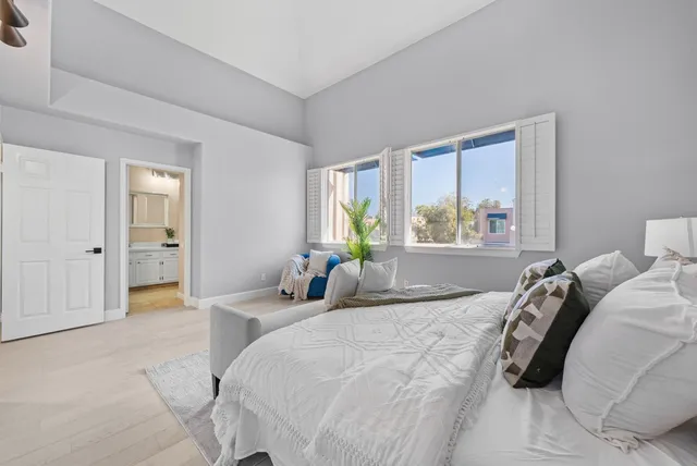 a bedroom with a bed and a large window