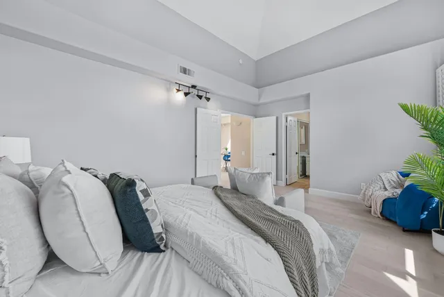 a spacious bedroom with a bed and a potted plant