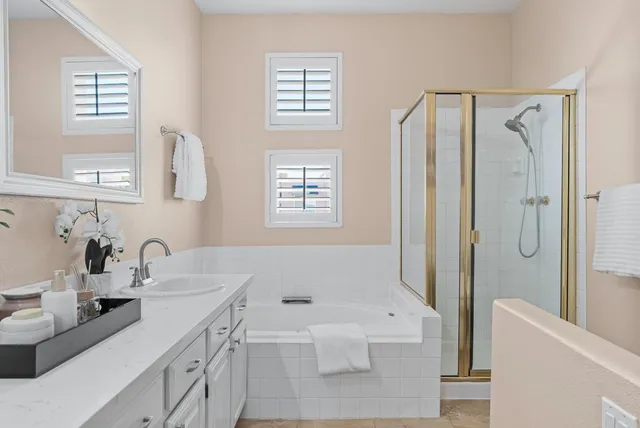 a bathroom with a tub a sink and a large mirror