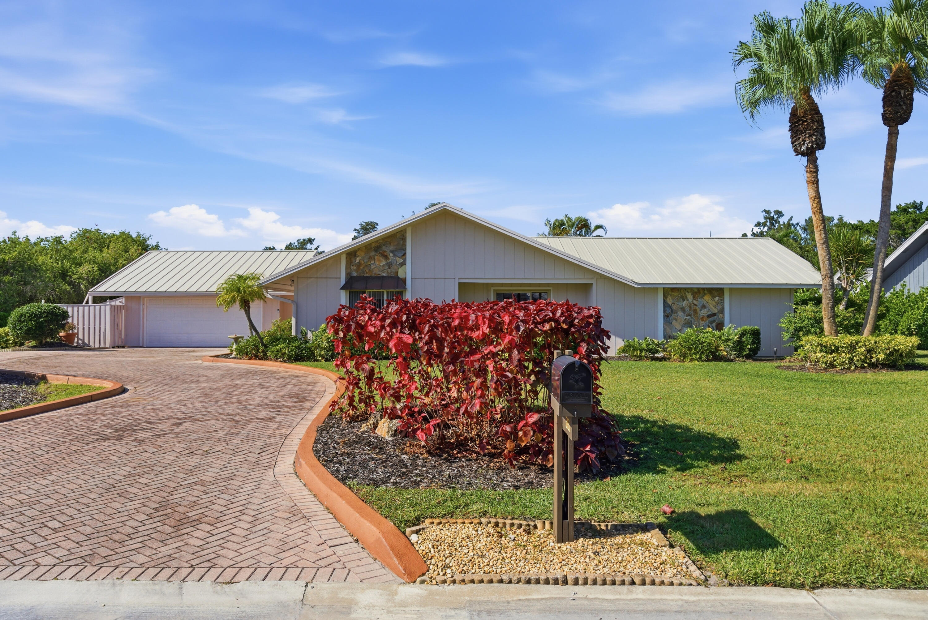 5151 Southeast Burning Tree Circle Stuart, FL 34997 - Photo 2 of 74 a front view of a house with garden