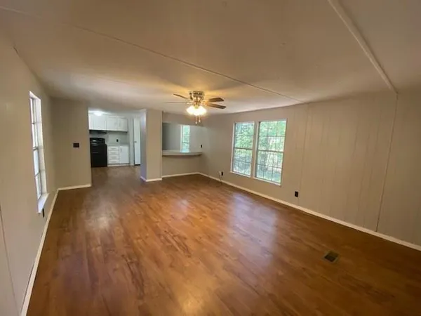 an empty room with wooden floor and windows