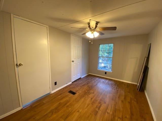 1058 East Owings Street Denison, TX 75021 - Photo 5 of 9 a view of an empty room with window wooden floor and a chandelier fan