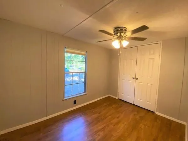 an empty room with windows and fan