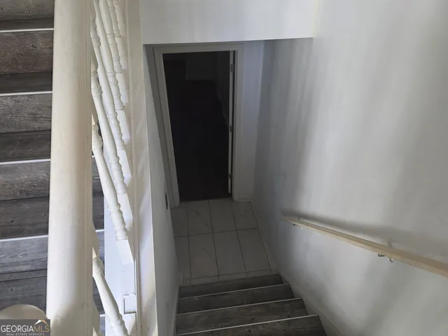 a view of staircase with white walls and door