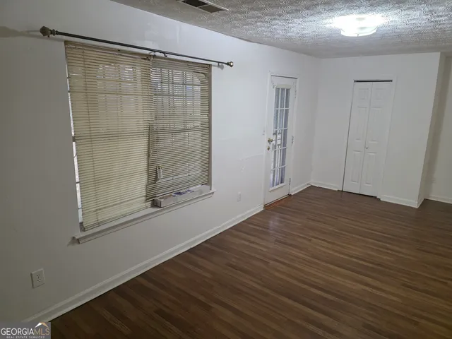 a view of a small space with wooden floor and a window