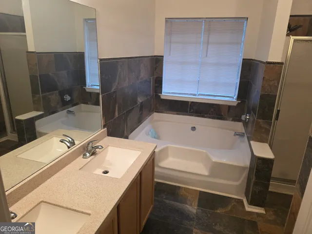 a bathroom with a tub sink and mirror