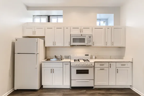 a kitchen with white cabinets and white appliances