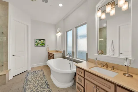 a bathroom with a tub sink and mirror