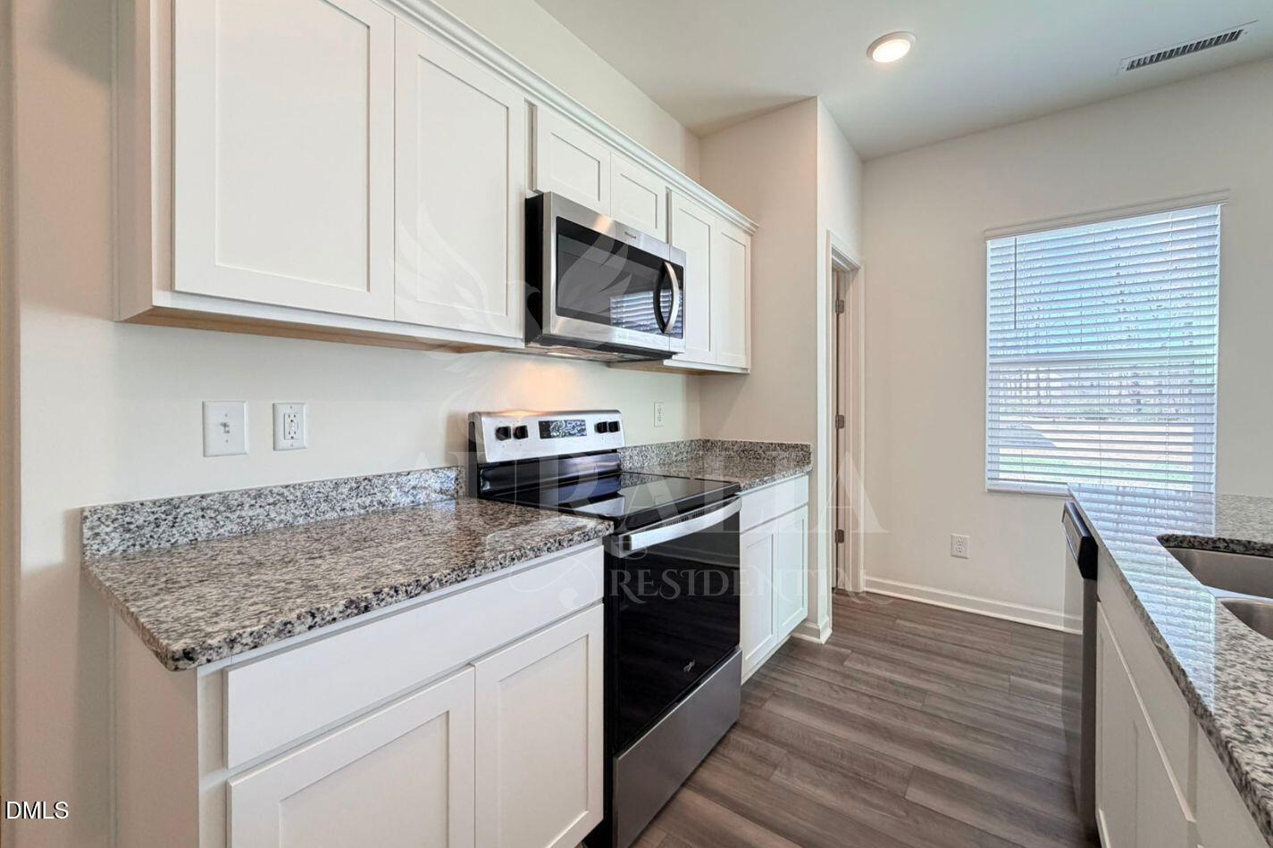 937 Berkeley Glen Road Zebulon, NC 27597 - Photo 13 of 35 a kitchen with stainless steel appliances granite countertop a stove a sink and a microwave