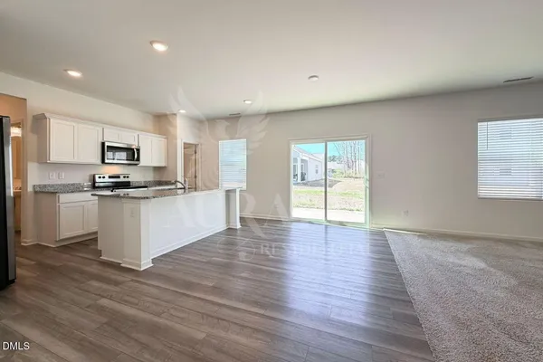 a kitchen with granite countertop a refrigerator and a stove top oven