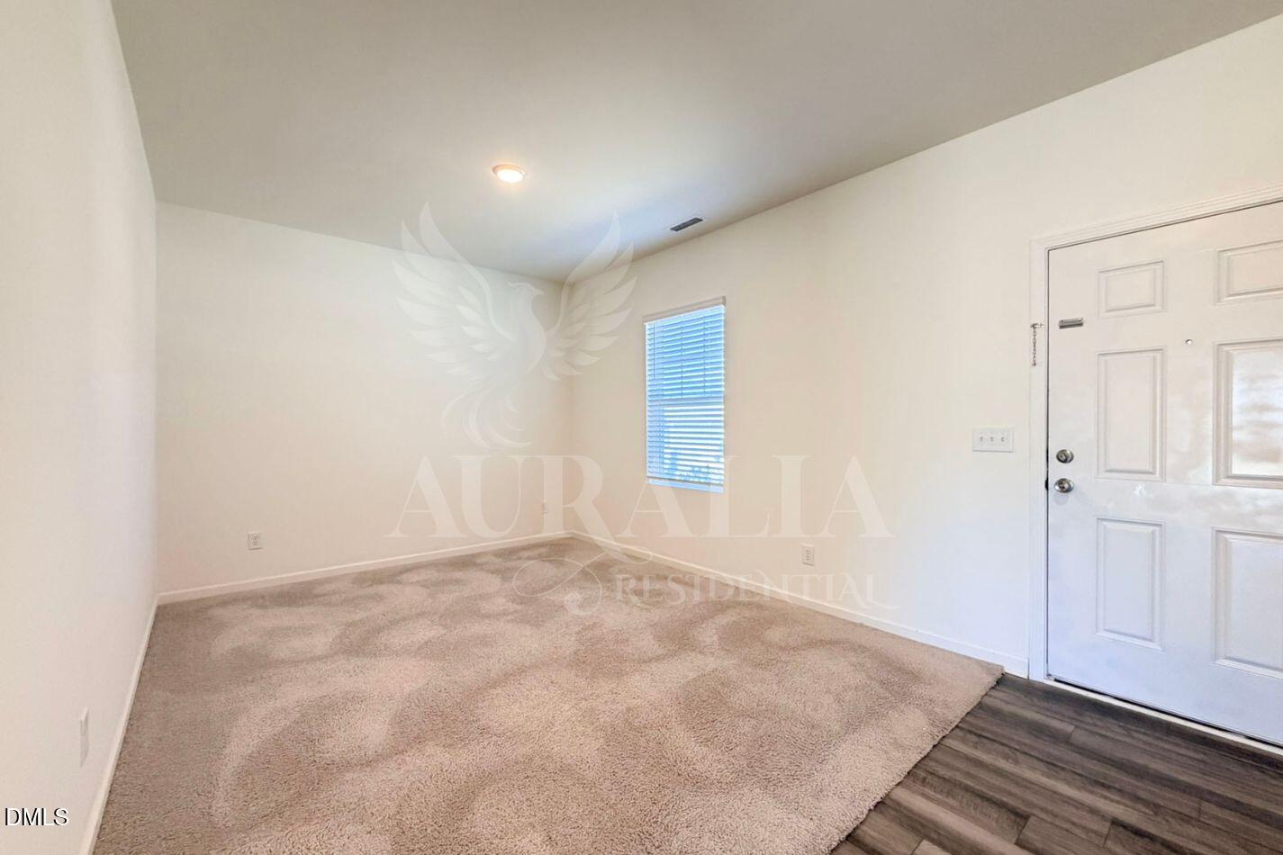 937 Berkeley Glen Road Zebulon, NC 27597 - Photo 4 of 35 an empty room with wooden floor and windows