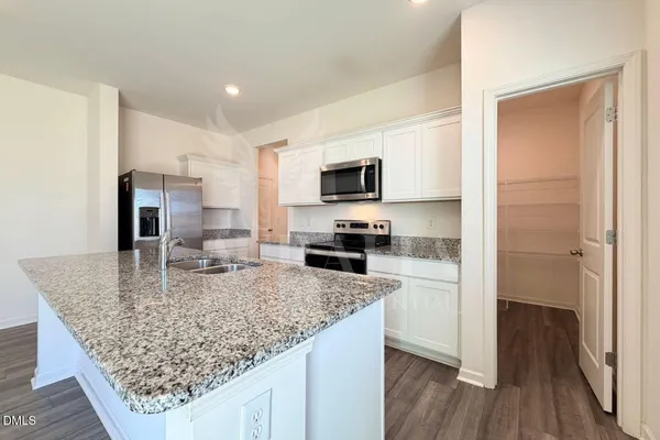 a kitchen with stainless steel appliances granite countertop a sink refrigerator and microwave