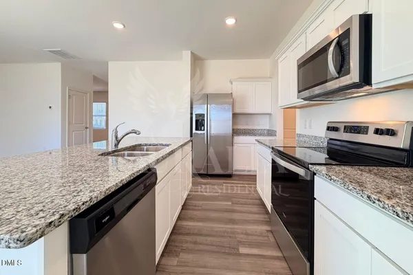 a kitchen with stainless steel appliances granite countertop a sink stove microwave and cabinets