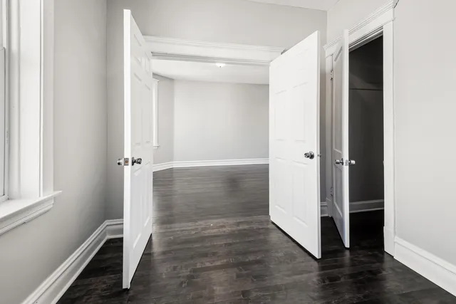 an empty room with wooden floor and a window