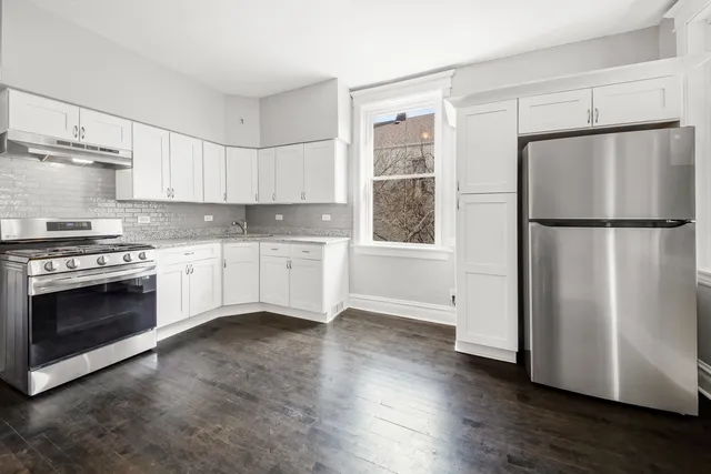 a kitchen with a refrigerator stove and wooden floor