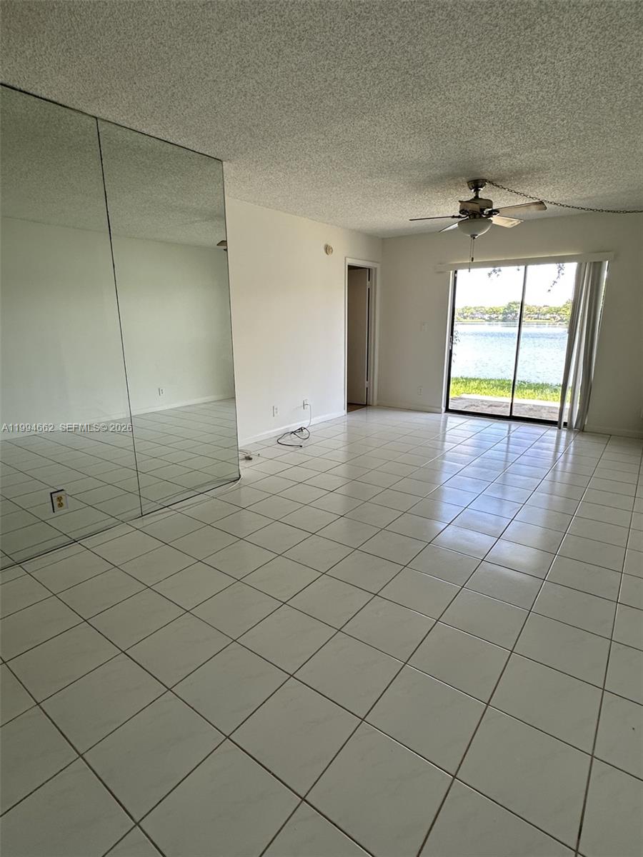 10003 Winding Lake Road, Unit 103 Sunrise, FL 33351 - Photo 6 of 12 an empty room & glass door