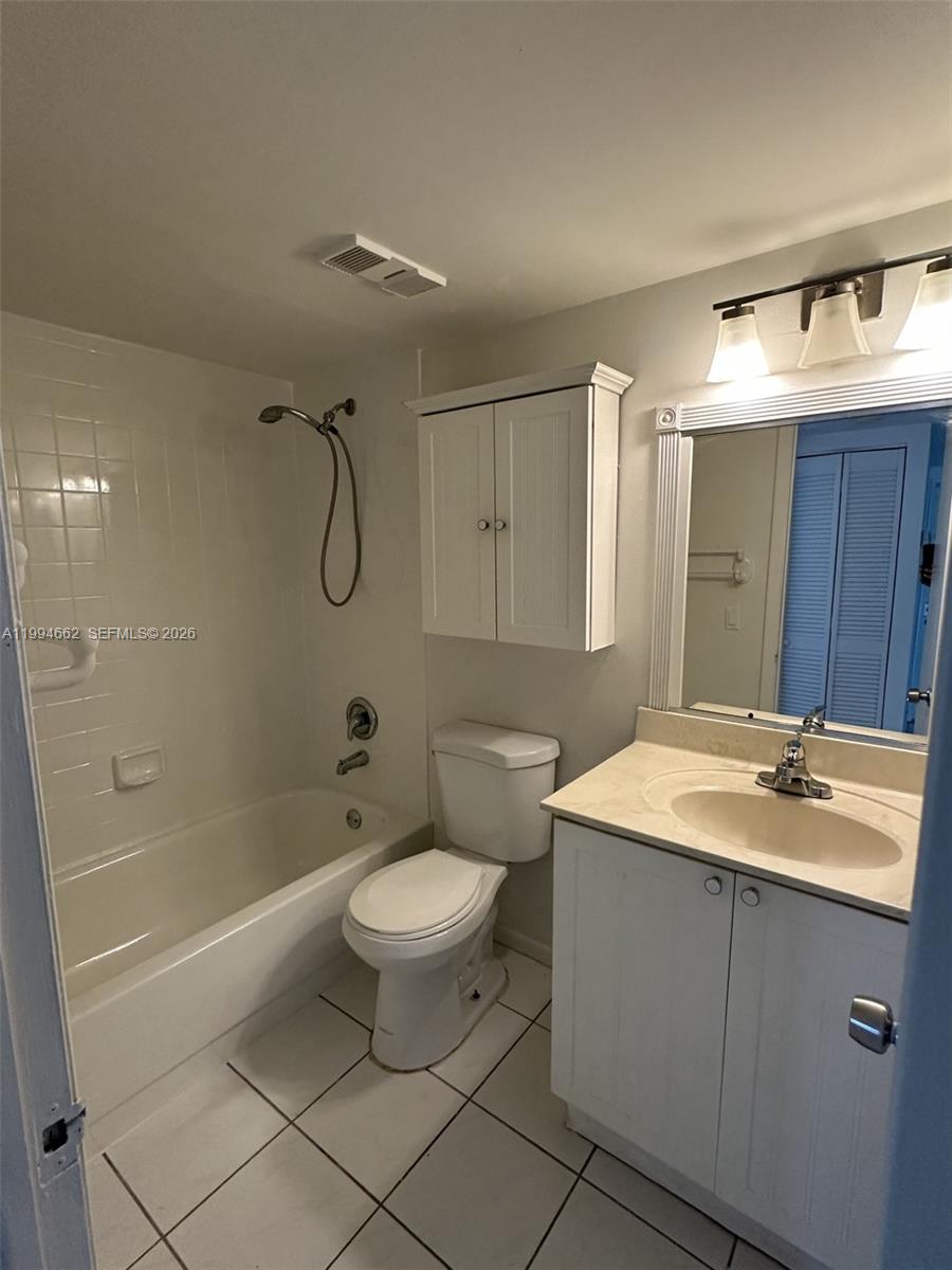 10003 Winding Lake Road, Unit 103 Sunrise, FL 33351 - Photo 8 of 12 a bathroom with a sink a toilet and shower