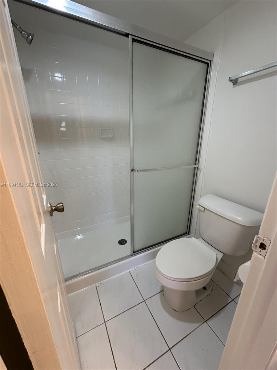 10003 Winding Lake Road, Unit 103 Sunrise, FL 33351 - Photo 9 of 12 a bathroom with a toilet and a shower