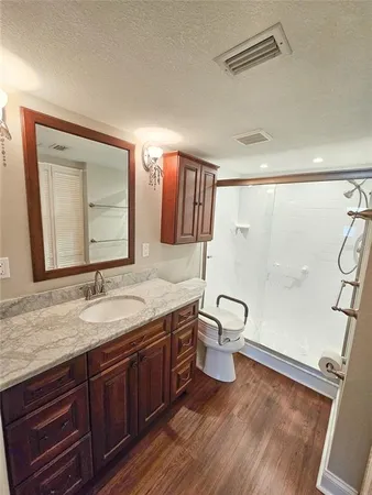 a bathroom with a granite countertop sink toilet a mirror and shower