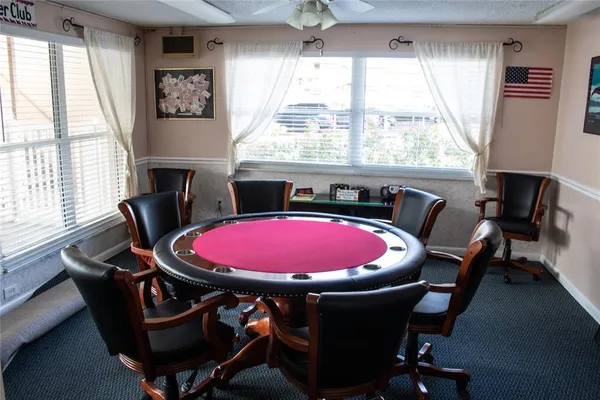 a room with pool table windows and chairs