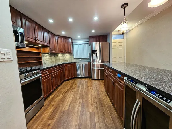a kitchen with stainless steel appliances granite countertop a stove and a sink