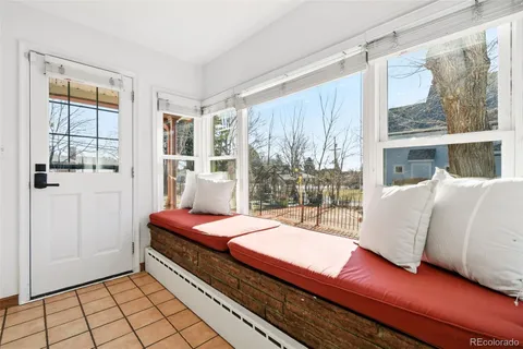 a kitchen with stainless steel appliances kitchen island granite countertop a refrigerator a stove and white cabinets with wooden floor