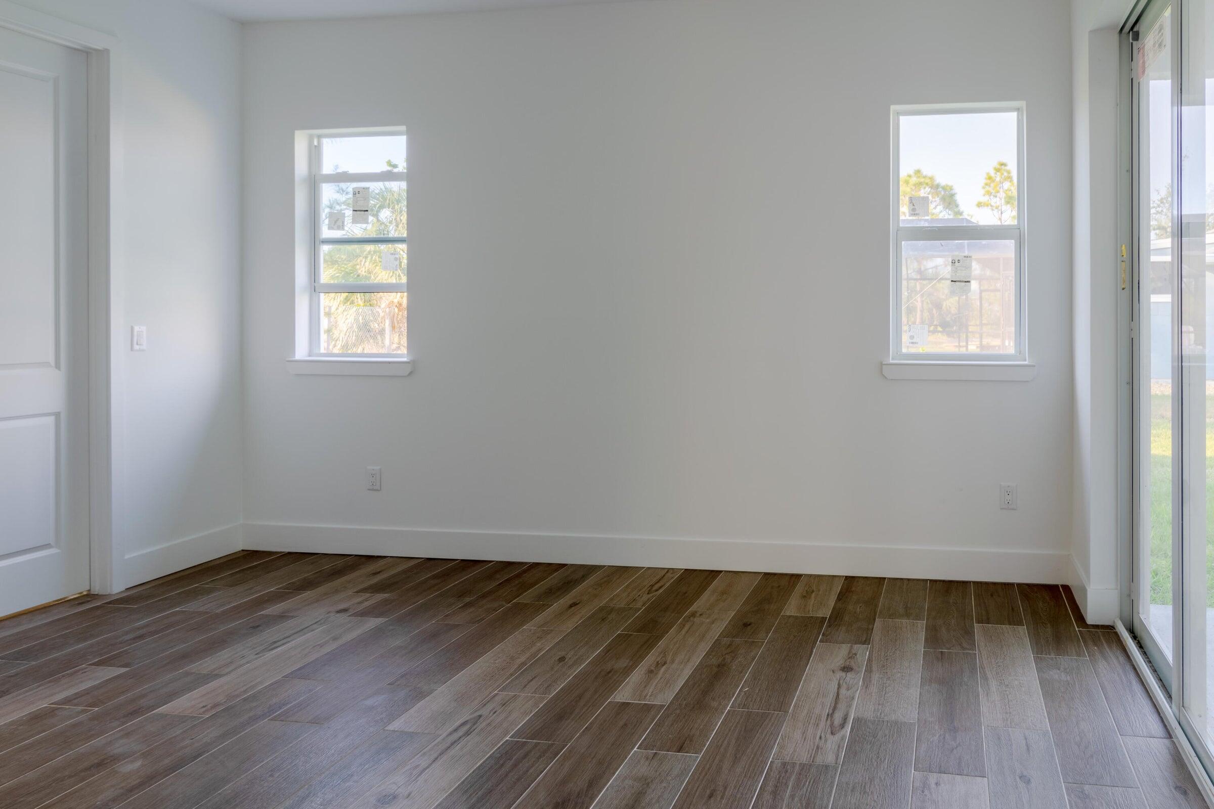 10625 Ayear Road Port Charlotte, FL 33981 - Photo 19 of 33 an empty room with wooden floor and windows