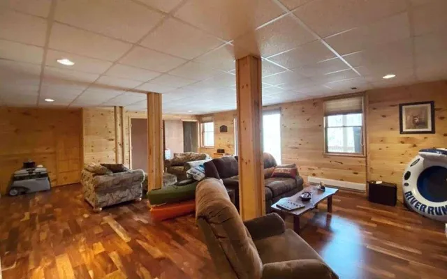 a living room with furniture floor to ceiling window and a flat screen tv