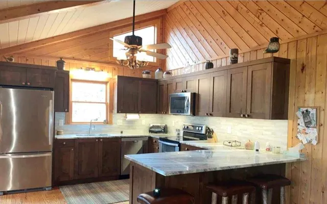 a kitchen with stainless steel appliances granite countertop a sink refrigerator and cabinets