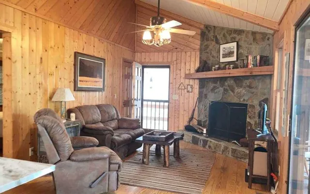 a living room with furniture a fireplace and a chandelier