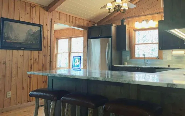 a kitchen with granite countertop a stove a sink and a microwave
