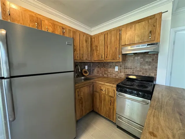 a kitchen with a refrigerator a stove a sink and cabinets