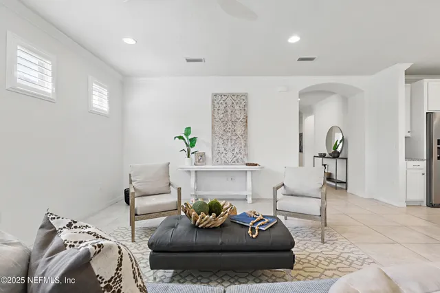 a living room with furniture a large window and wooden floor