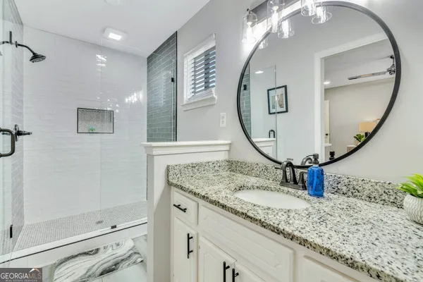a bathroom with a sink vanity and a mirror