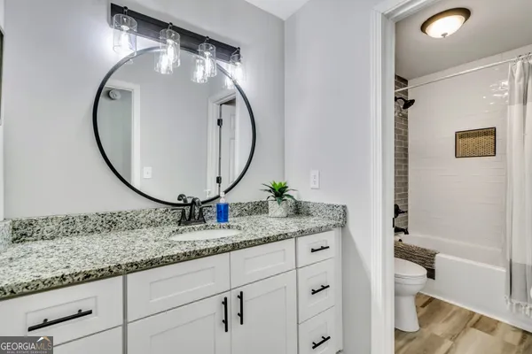 a bathroom with a granite countertop sink and a mirror