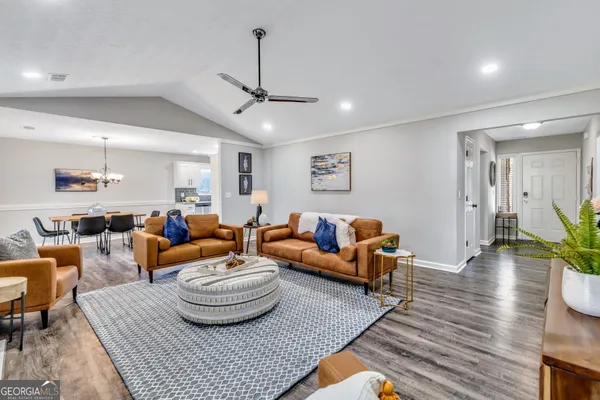 a living room with furniture and a wooden floor